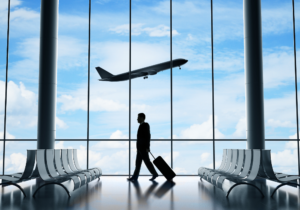 business man at the airport with an airplane in the background