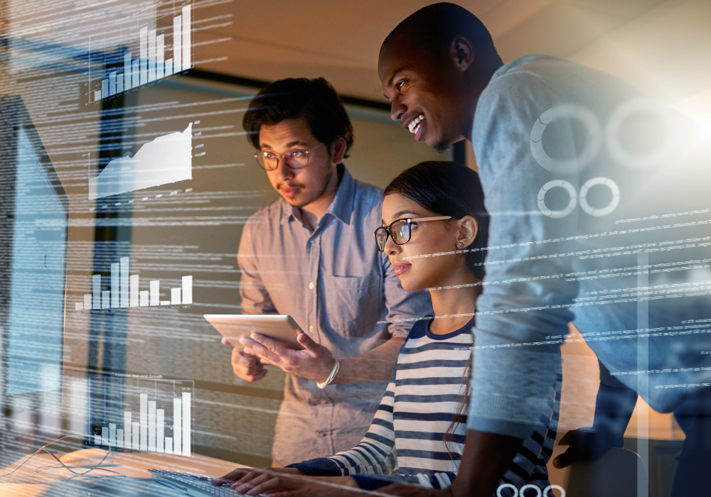 Tech professionals collaborating in front of a computer