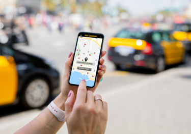 Close-up of Person's Hand Using Ride Sharing App on Phone