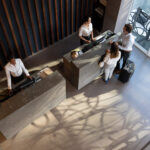 Aerial shot of a couple checking in at a modern hotel front desk