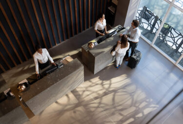 Aerial shot of a couple checking in at a modern hotel front desk